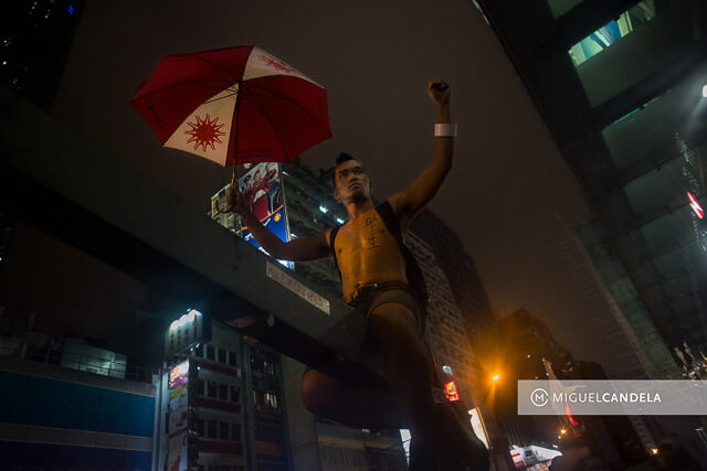 Manifestante asiático con paraguas símbolo de la revolución 